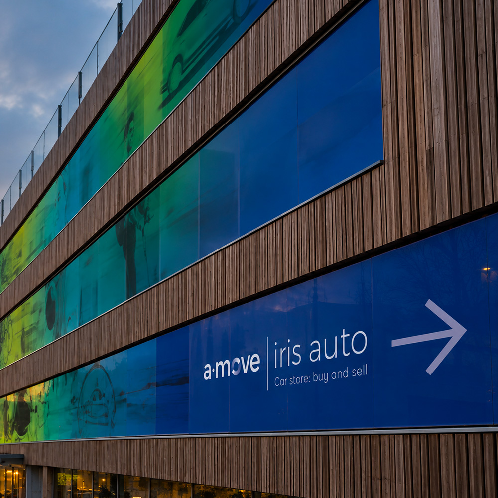 A‑Move / Iris Auto — détail de la bâche Détail du visuel A‑Move et Iris Auto sur une bâche de façade.