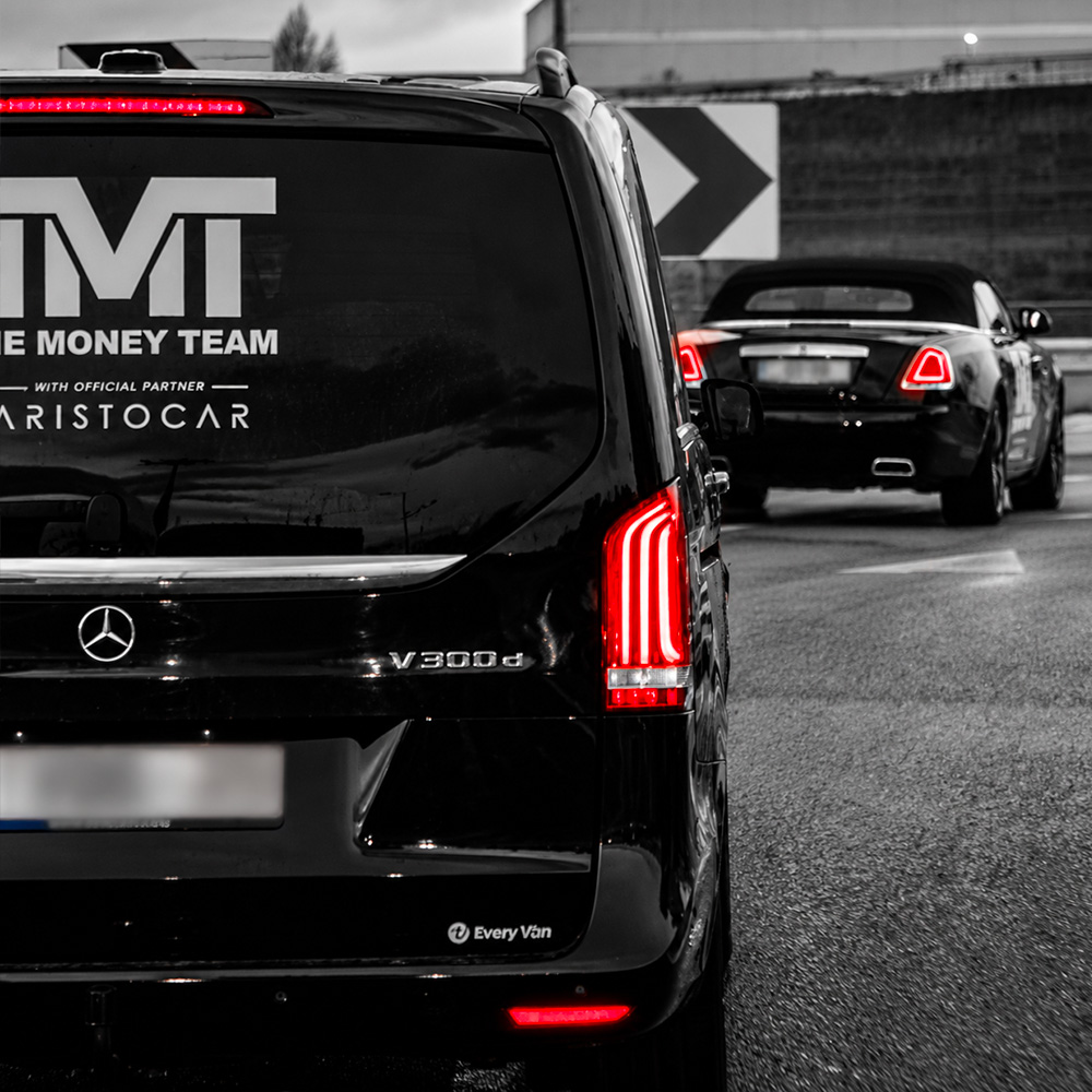 Lettrage TMT et Aristocar sur la vitre arrière d’un véhicule Mercedes noir.