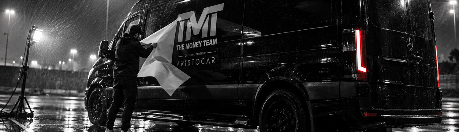 Reconstitution de la pose du lettrage TMT sur un Mercedes Sprinter, de nuit sous la pluie.