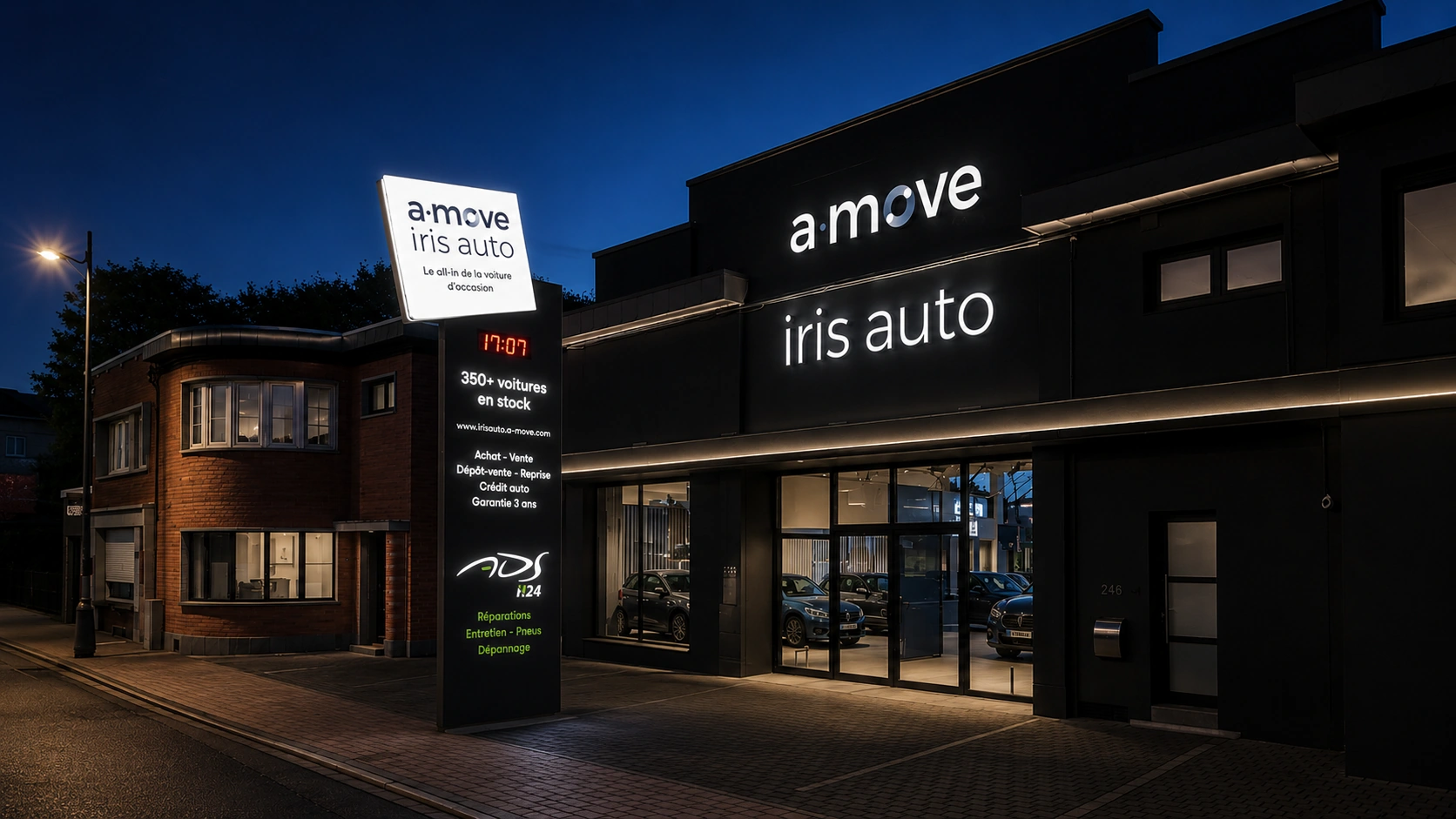 Concessionnaire-automobile-illumine-de-nuit Enseignes lumineuses A‑Move et Iris Auto et totem éclairé devant le site d’Ans.