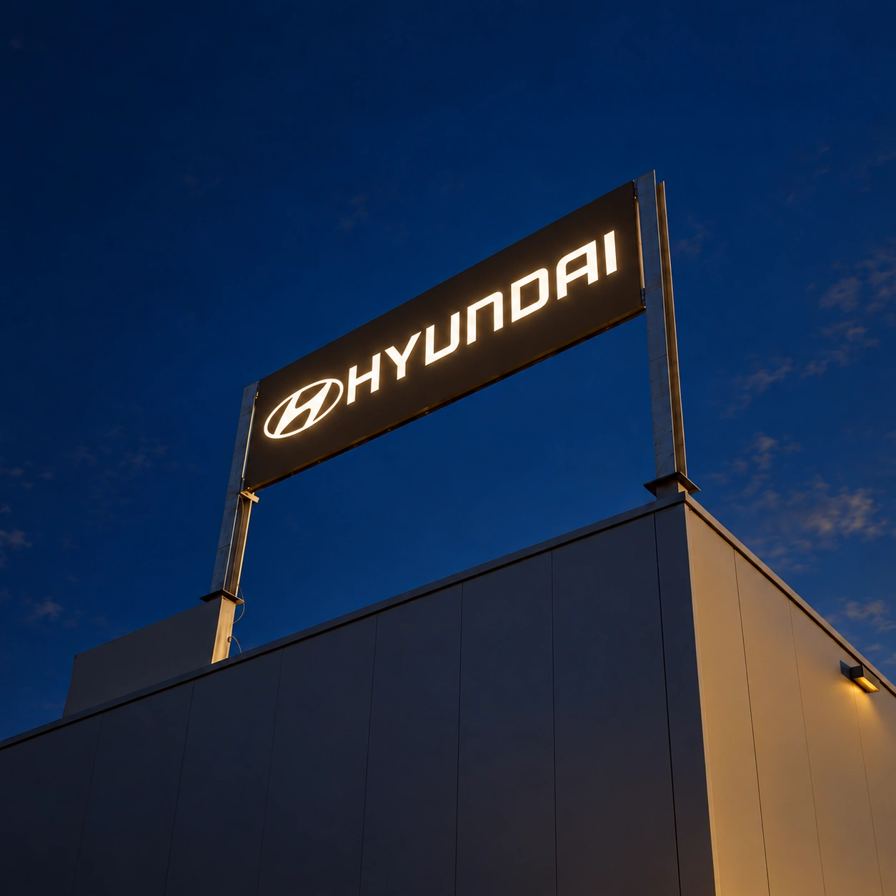 hyundai-awans-nuit-lumiere-v2 Enseigne lumineuse Hyundai sur caisson noir à Awans, de nuit.