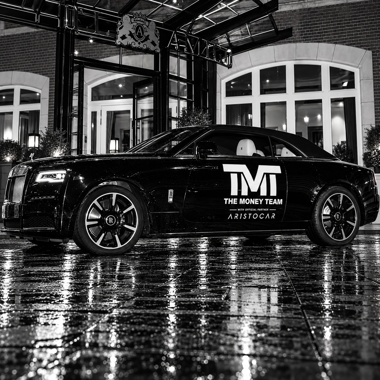 Rolls-Royce marquée TMT devant l’Hôtel Amigo, en noir et blanc