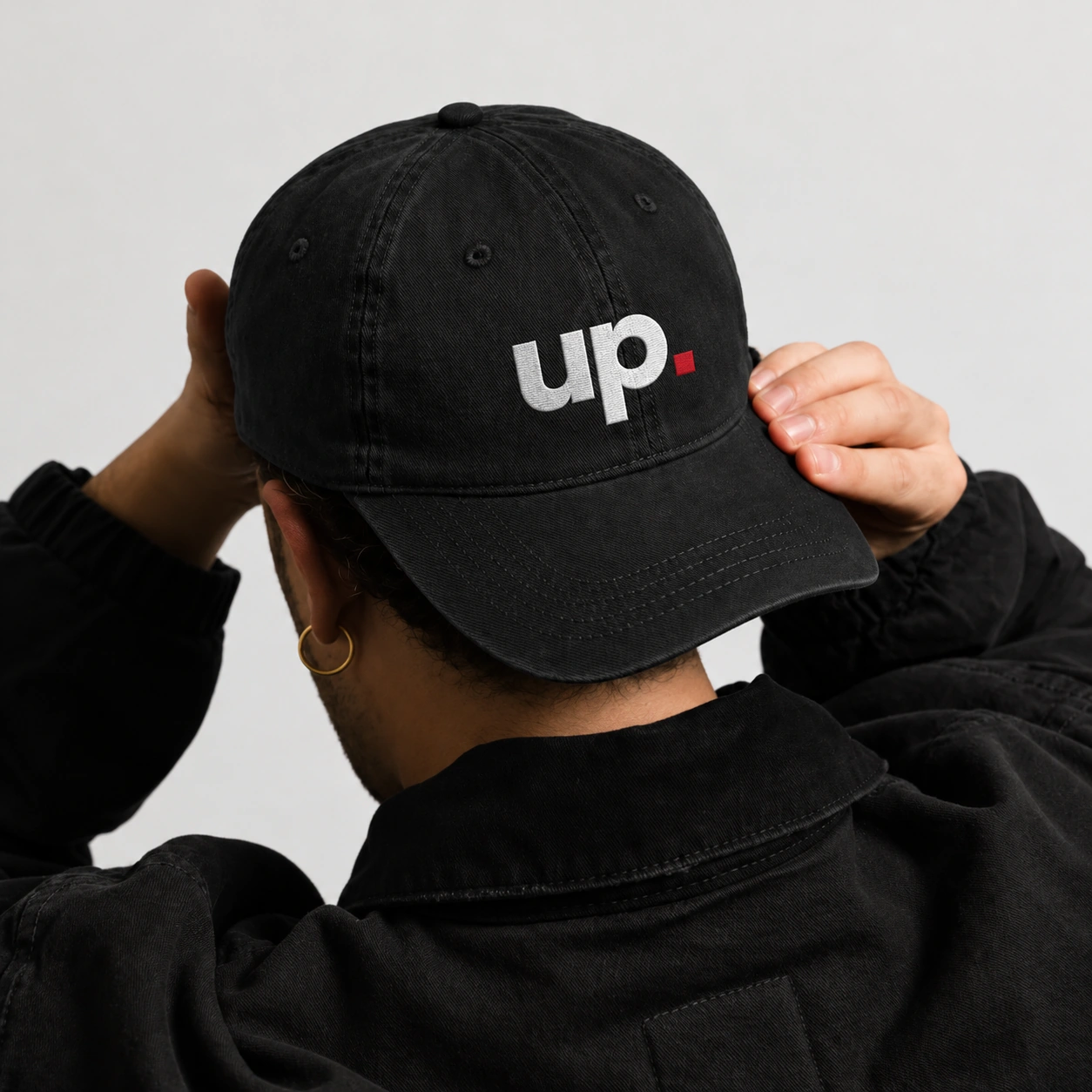 Casquette noire brodée du monogramme UP et du carré rouge.